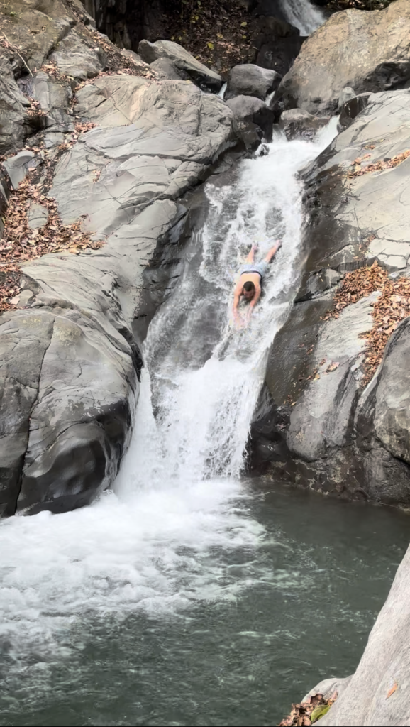 Riding one of the natural rock waterslides into the pool below. Photo: Shawn Brooks Photography